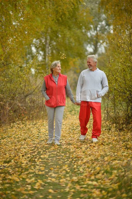 Happy fit senior couple in autumn park, stock photo