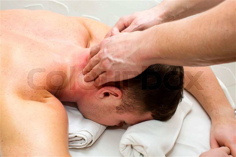 Man doing sports massage at the massage parlor, stock photo
