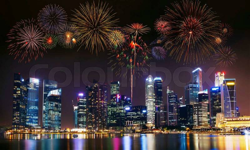 Multiple fireworks exploding high in the sky over modern building in city, stock photo