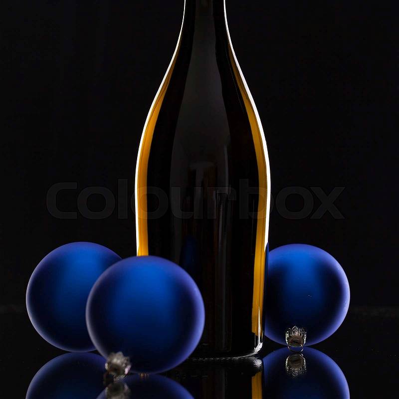 The bottle of red wine and Christmas decoration on a black glass desk, stock photo