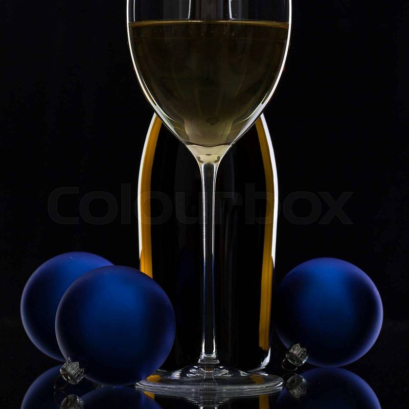 The bottle of white wine and Christmas decoration on a black glass desk, stock photo