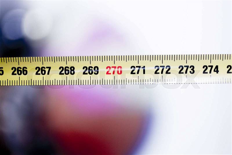 Measuring tape metal ruler showing measuement in centimeters (cm) numbers on plain background, stock photo