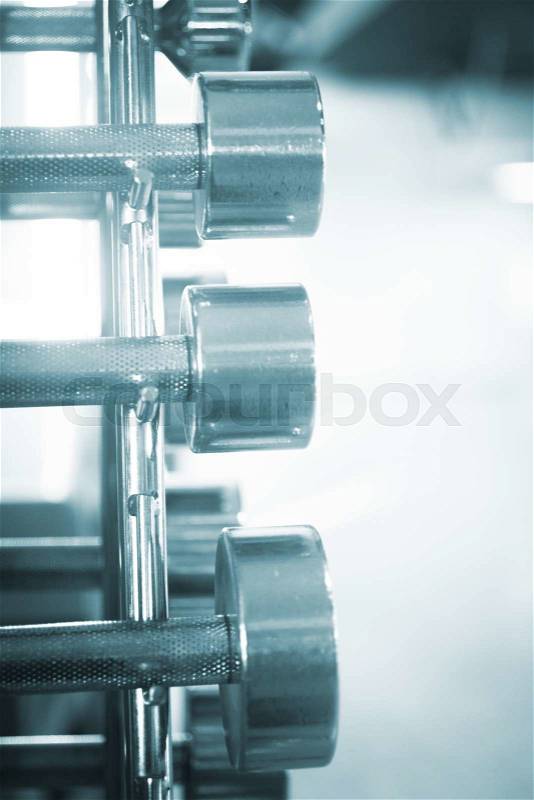 Exercise and fitness metal dumbell weights in gym on rack for weight training and bodybuilding, stock photo