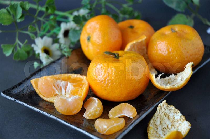 Close up fresh oranges peeled put on black plate, stock photo