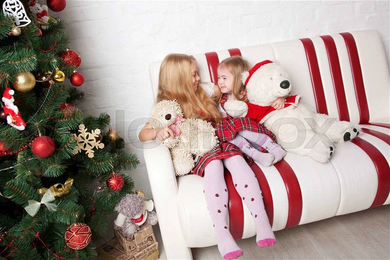 Happy children with teddy bears under the Christmas tree. Winter holidays, stock photo