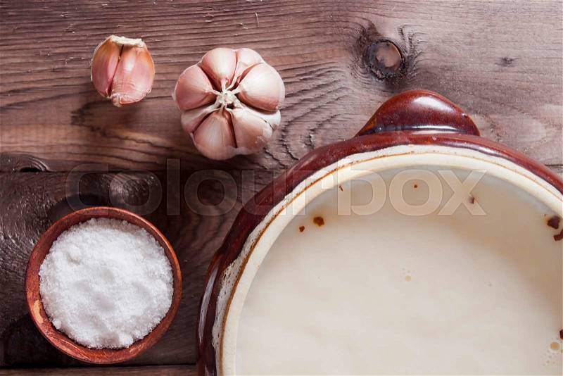 Pig fat in ceramic ware and garlic on the kitchen table, stock photo