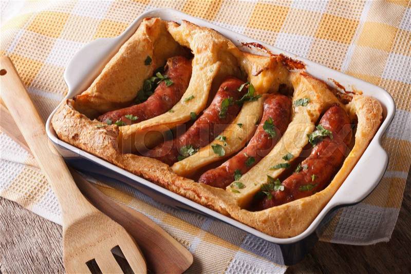 English food: toad in the hole into a baking dish close up on the table. Horizontal , stock photo