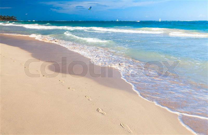 Empty sandy beach landscape with footsteps in coastal sand. Atlantic ocean coast, Dominican republic. Punta Cana, stock photo