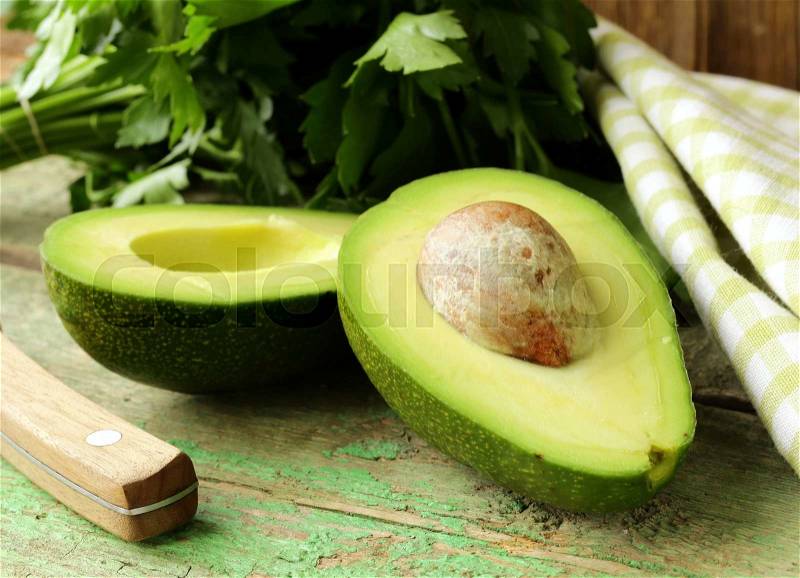 Ripe avocado cut in half on a wooden table, stock photo