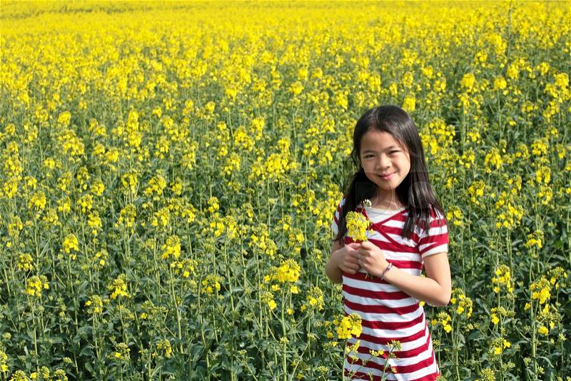 Cute girl in denmark in a rapse field, stock photo