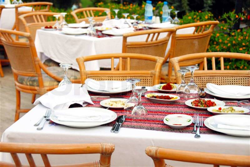 Outdoor table with served plate and wine glasses, stock photo