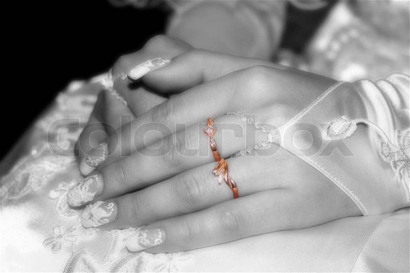 The moment of expectation of the groom, hand of the bride are combined on a dress, gold rings on fingers, a black-and-white photo, rings in colour, stock photo