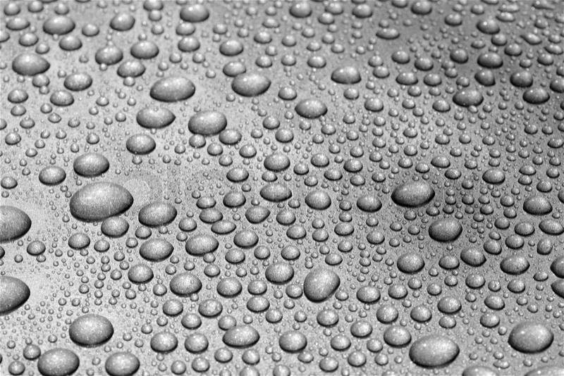 Water beads on a metallic dark grey car. The image may appear noisy, but that is caused by the metallic paint, stock photo
