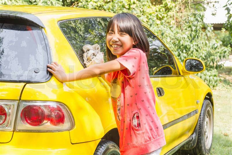 Washing Car, Little asian kid girl washing old yellow car on the grass, stock photo