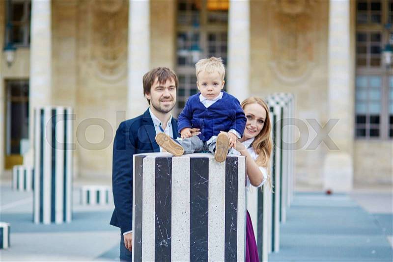 Happy family of three in the beautiful garden in Paris, stock photo