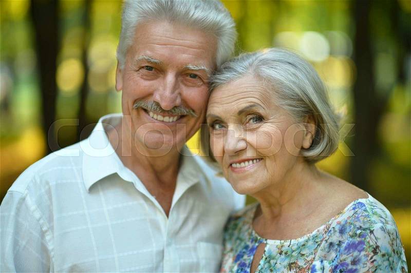 Loving mature couple in a summer park, stock photo