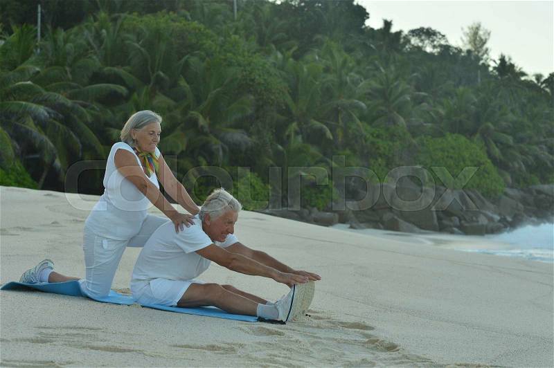Happy Senior couple exercising in summer on seashore, stock photo