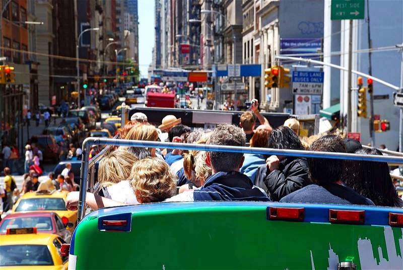 City sight bus on crowded street with tourists, stock photo