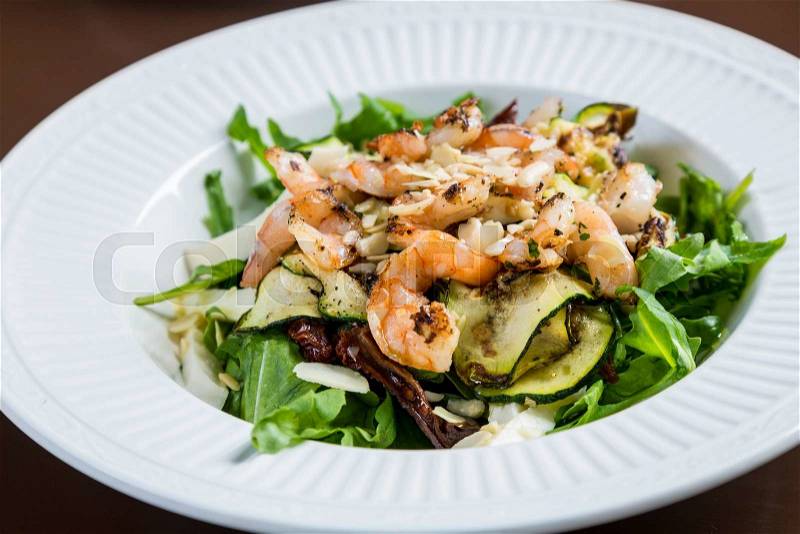 Shrimp salad with grilled zucchini, dried tomatoes, mozarella cheese and almonds, stock photo