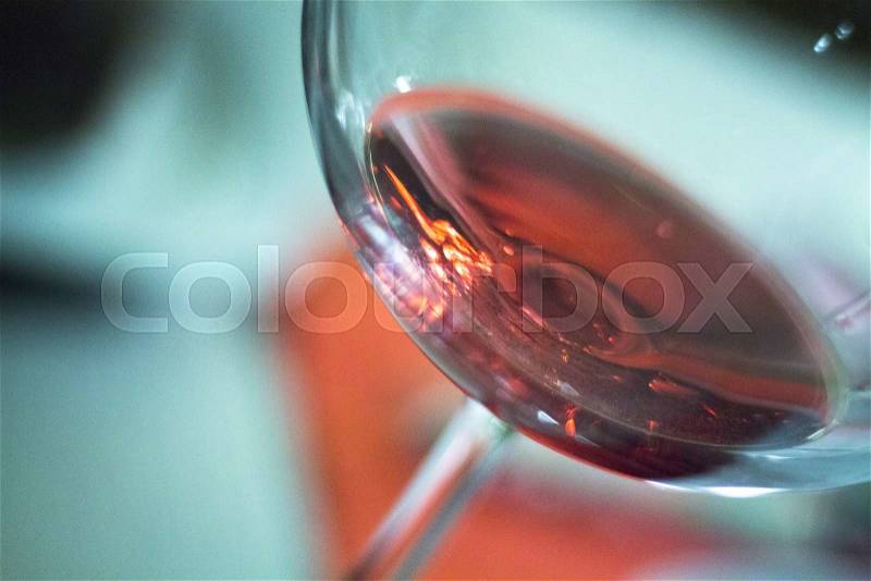 Rose pink wine glass in restaurant at night during wedding reception party, stock photo
