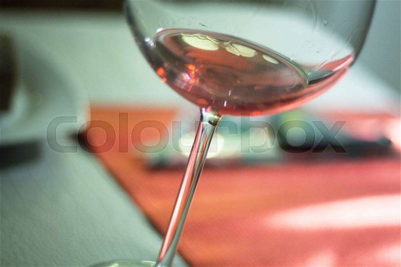 Rose pink wine glass in restaurant at night during wedding reception party, stock photo