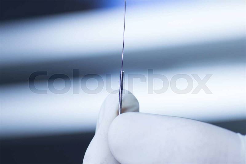 Acupuncture needle used for dry needling rehabilitation medical treament for physiotherapy and pain due to physical injury in the hand of the doctor, stock photo