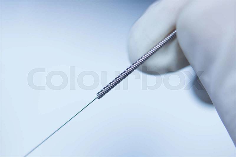 Acupuncture needle used for dry needling rehabilitation medical treament for physiotherapy and pain due to physical injury in the hand of the doctor, stock photo