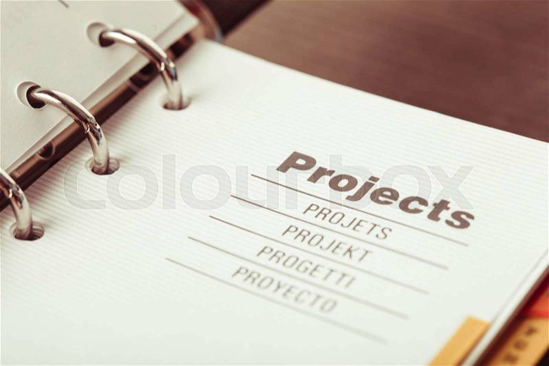 The word projects in different languages closeup in organizer, stock photo