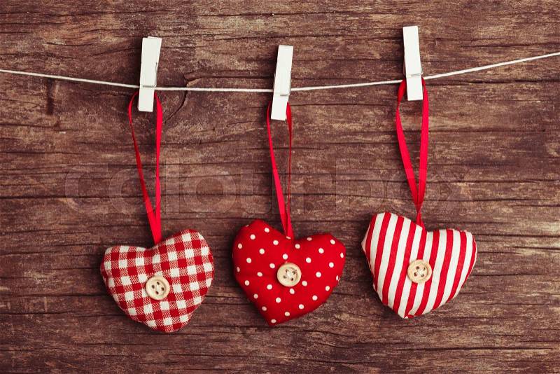 White and red sewed christmas hearts attached to the rope. Holiday background for greetings Valentine\'s day, stock photo