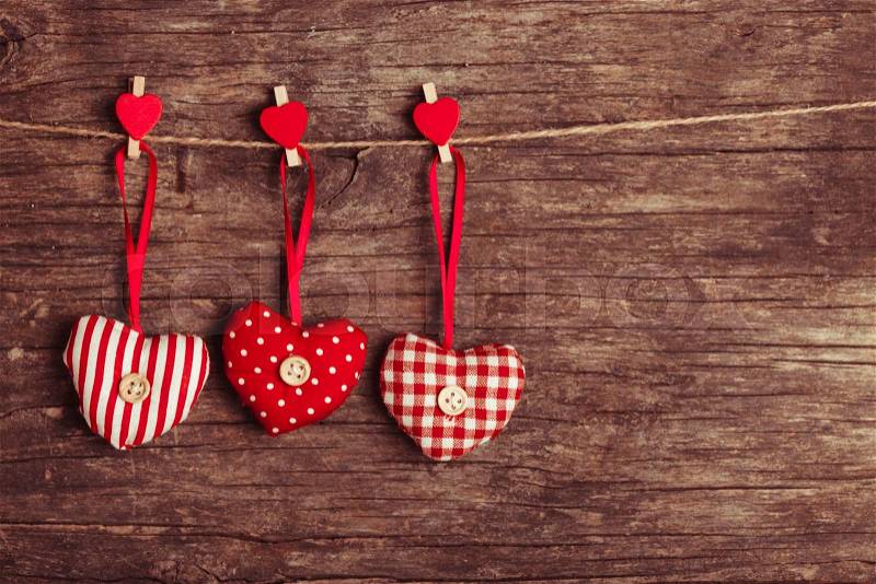 White and red sewed christmas hearts attached to the rope. Holiday background for greetings Valentine\'s day, stock photo