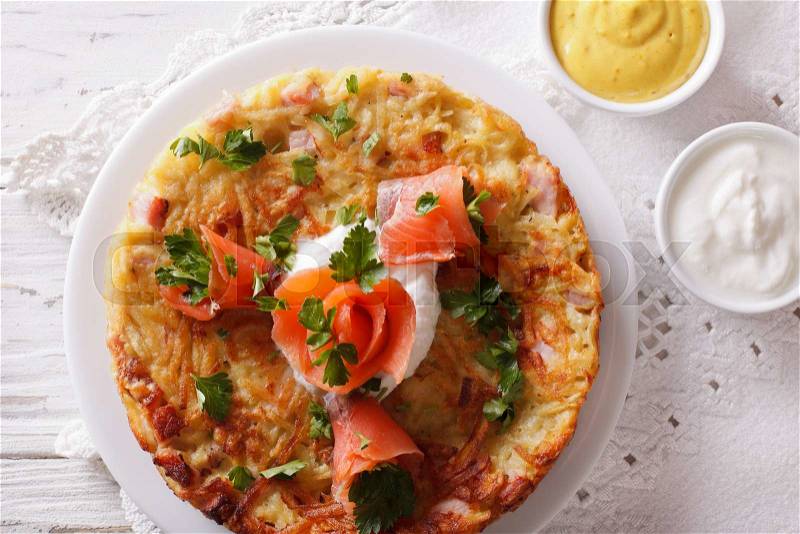 Potato pancakes with smoked salmon and sauce on a plate close-up. Horizontal top view , stock photo