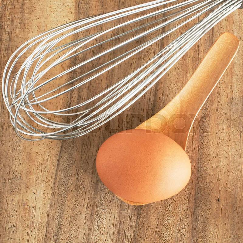 Fresh brown eggs in wooden spoon on table, stock photo