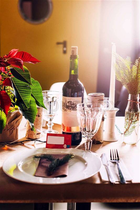 Decorated Christmas holiday table ready for dinner. Beautifully decorated table set with candles, spruce twigs, plates and serviettes for event in the restaurant, stock photo