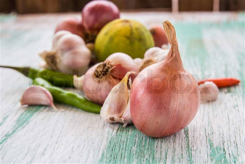 Fresh organic red onion garlic and lemon on wooden background, stock photo