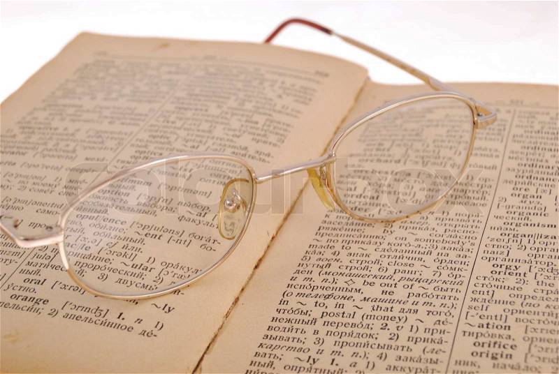 The opened book and glasses on the book and all it on a white background, stock photo