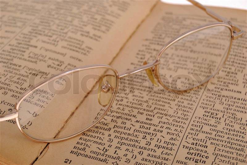 The opened book and glasses on the book and all it on a white background, stock photo