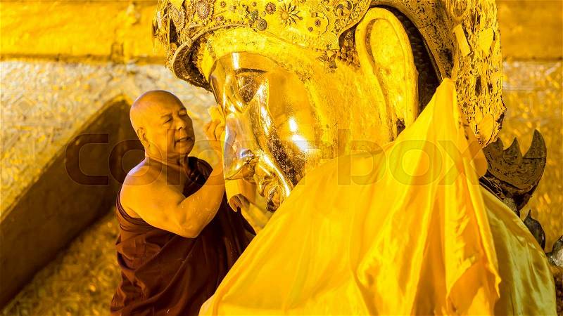 MANDALAY - FEB 19: The senior monk wash Mahamuni Buddha image in ritual of the Buddha image face wash on February 19, 2015 at Mahamuni temple in Mandalay, Myanmar.This ritual commences every morning, stock photo
