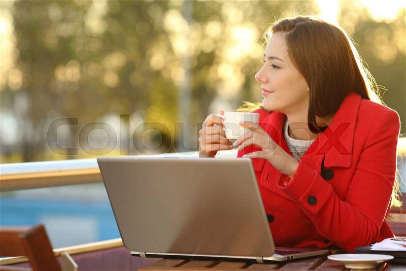 Entrepreneur with a laptop relaxing in a coffee shop and looking forward, stock photo