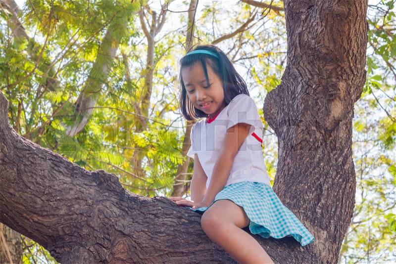 Close up asian children climbing trees are afraid of falling trees, stock photo