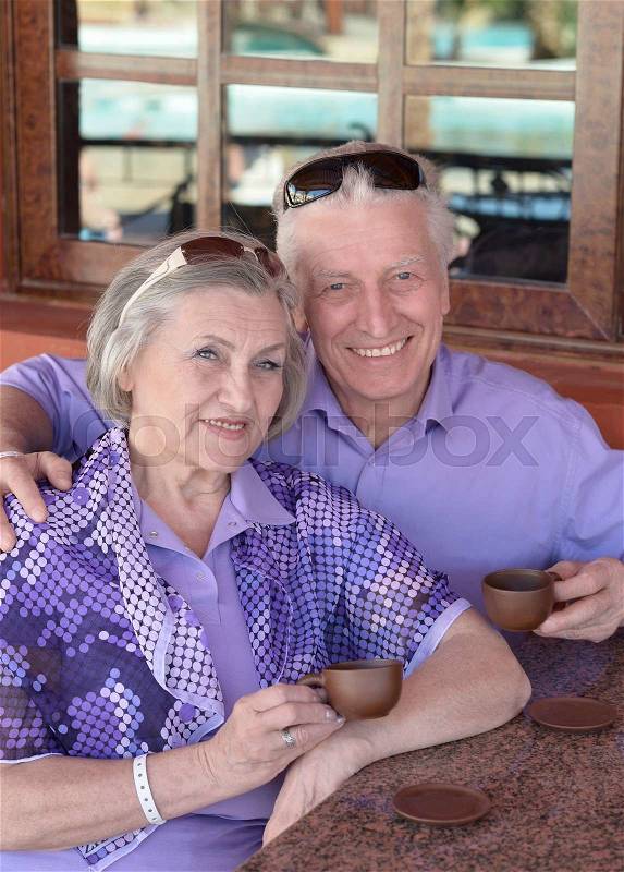 Senior couple drinking coffee at the resort during vacation, stock photo