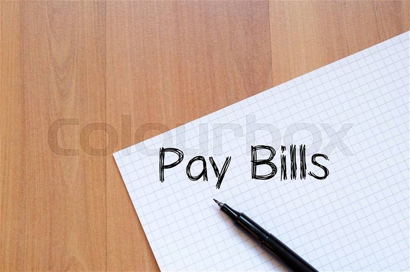 Pay bills text concept write on notebook with pen, stock photo