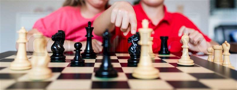 Young white child playing a game of chess on large chess board, stock photo