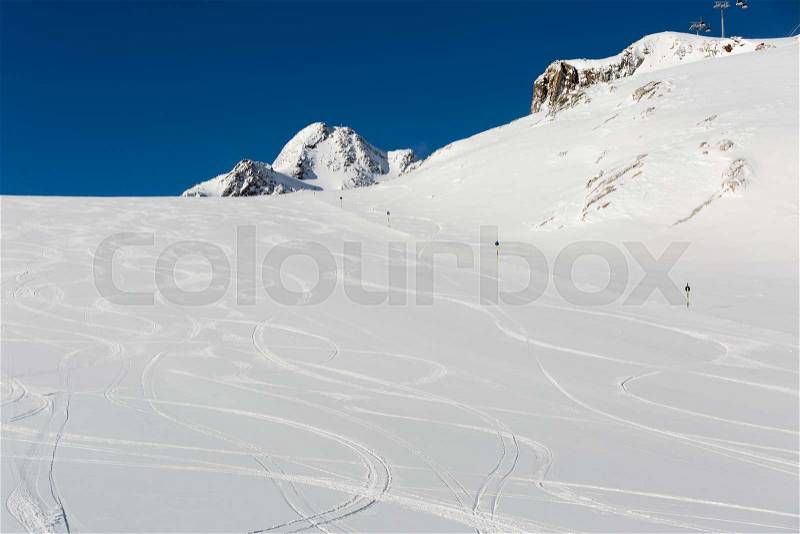 Fresh ski tracks on ski slope with new white snow at the ski resort Soelden in the Austrian Alps, stock photo