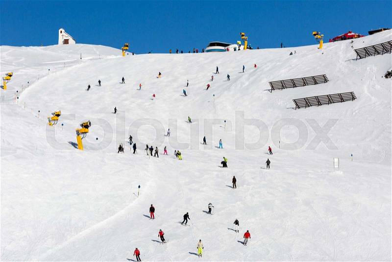 Skiers at ski run on a sunny day at the ski resort Soelden in Austria, stock photo