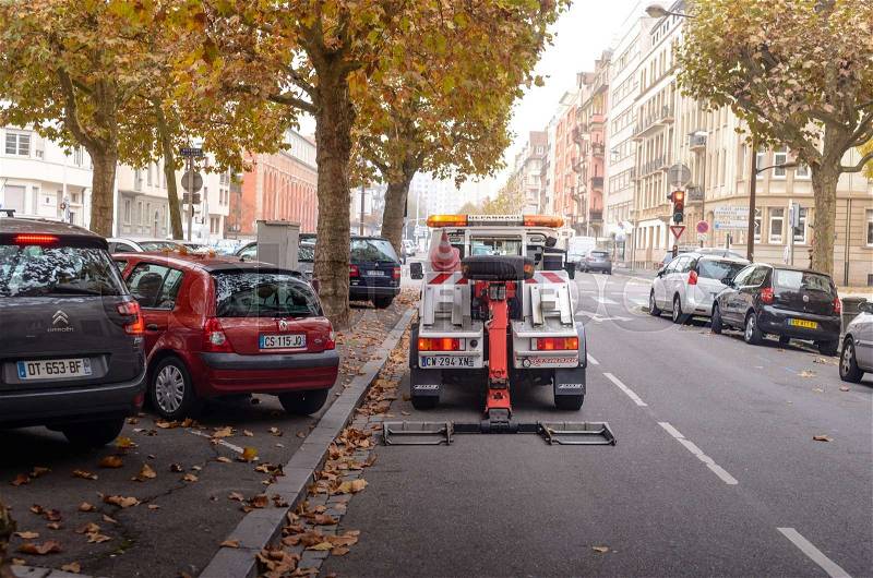 France, Strasbourg - 02 November 2015: City street along the road cars are parked under the tree with yellow leaves on the road is a technical assistance, stock photo