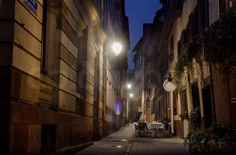 Night Street Strasbourg lit streetlights cozy cafe in an alley without customers, stock photo