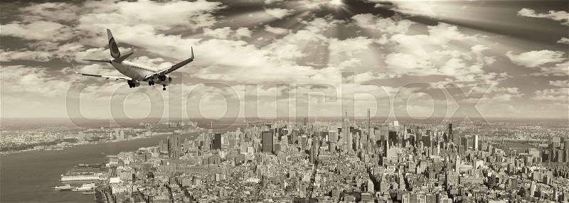 Black and white view of airplane over New York City. Tourism concept, stock photo