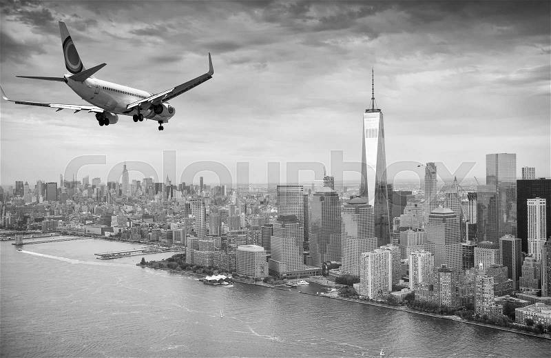 Black and white view of airplane over New York City. Tourism concept, stock photo