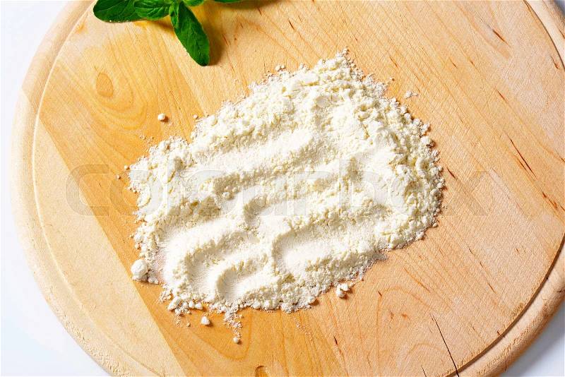 Soft wheat flour on round wood board, stock photo