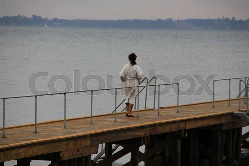Ritual in Denmark in the early morning, the solitary lady takes a swim in the sea, stock photo